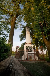 Kapliczka w formie kolumny, zwieńczona metalowym krzyżem, z drugiej połowy XIX-go wieku.